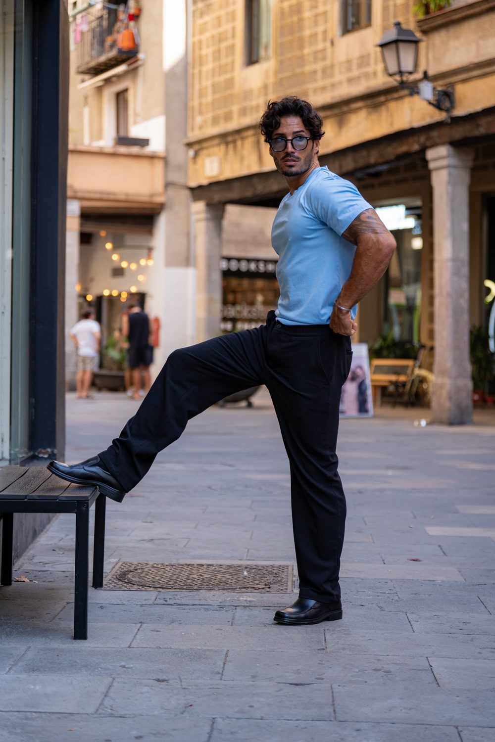Franco in a light blue tee, black trousers and loafers on a Barcelona street